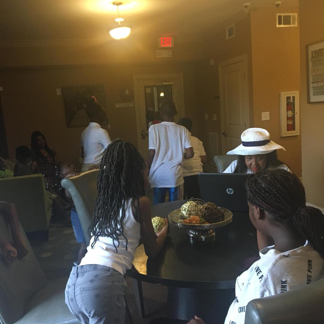 People gathered around living room table with laptop