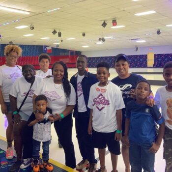 Smiling group wearing matching shirts at roller rink